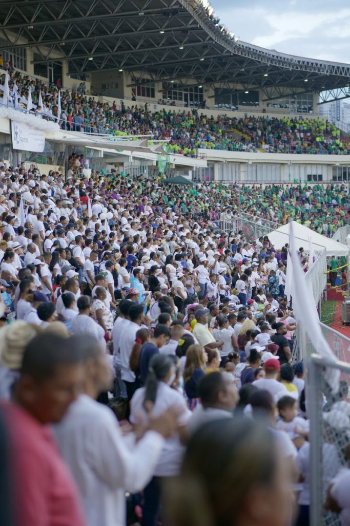 Home A bustling crowd fills the stadium during an outdoor event, showcasing diverse participants.