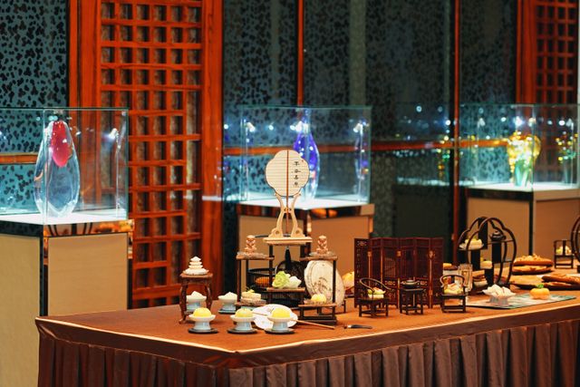 Luxurious dining table setup indoors with artistic glass displays and ambient lighting.